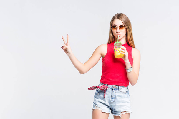 Pretty woman wearing casual clothes holding glass with orange juice isolated on white background - Фото, зображення