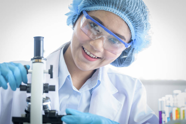 Asiatique yound étudiant scientifique de recherche avec un microscope dans un - Photo, image