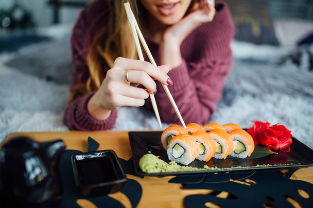 woman holding chopsticks, eating traditional cuisine, selective focus - Foto, afbeelding