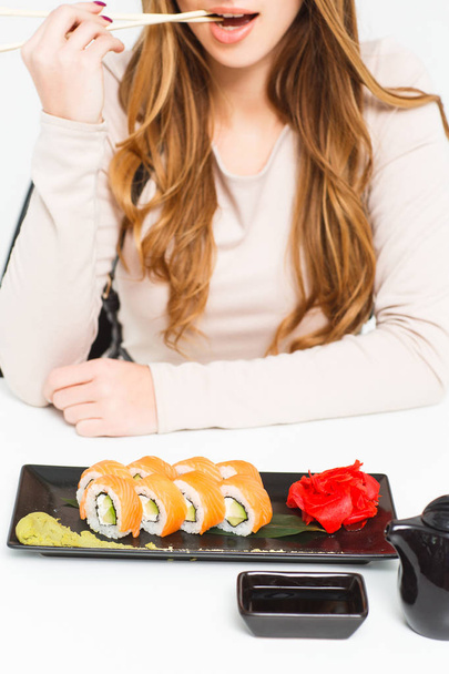 cropped view of woman eating sushi isolated on white background - Fotó, kép