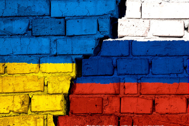 Flagi Ukrainy i Rosji na mur z duże pęknięcie w środku. Symbolem problemy między krajami - Zdjęcie, obraz