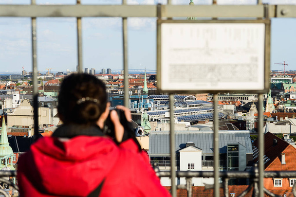 mulher tomando tiro de Rundetaarn, Ponte Oresund no horizonte
 - Foto, Imagem