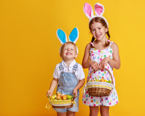 Смешной счастливый мальчик с пасхальными яйцами и кроличьими ушами на желе
 - Фото, изображение