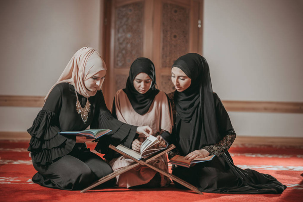 Trois filles musulmanes lisant le Coran dans une mosquée
 - Photo, image