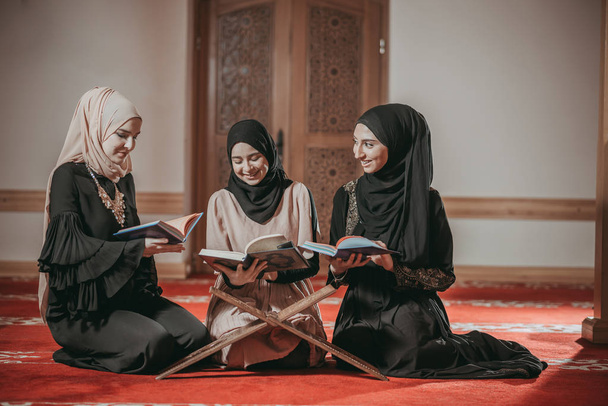 モスクでコーランを読んで 3 つのイスラム教徒の女の子 - 写真・画像
