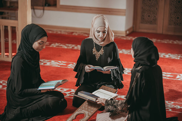 Trzy dziewczyny muzułmańskich czytanie Koranu w meczecie - Zdjęcie, obraz