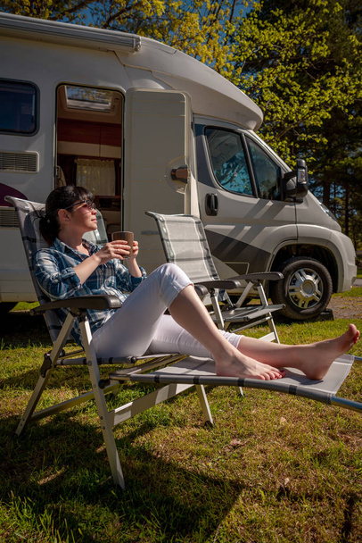Woman is standing with a mug of coffee near the camper RV. - Fotoğraf, Görsel