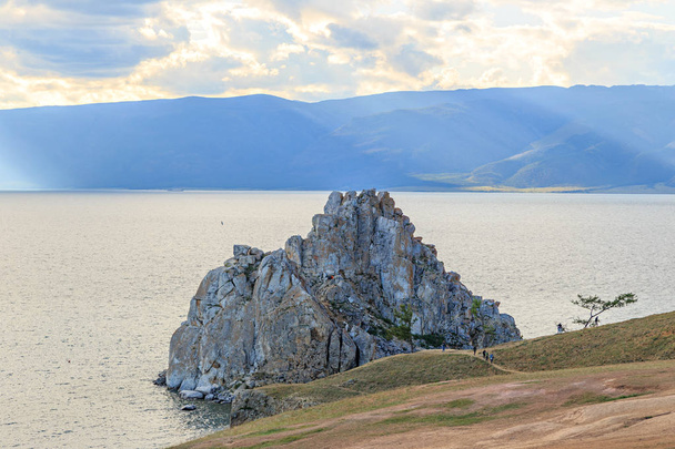 Venäjä, Baikal-järvi. Khuzhiriin. Turistit kävellä ympäri Shaman Rock
.  - Valokuva, kuva