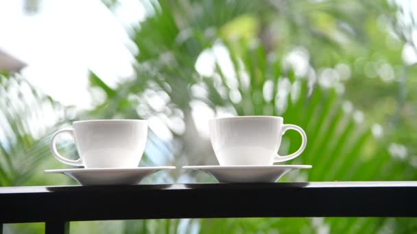 close-up footage of cups of coffee standing on balcony in front of nature background - Footage, Video