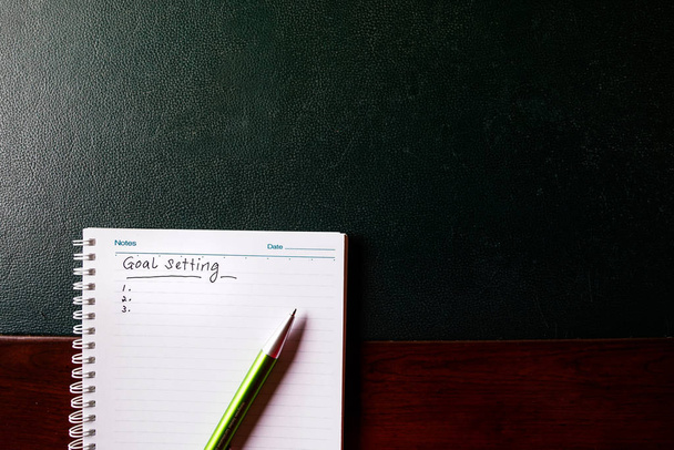 Goals setting to be written on a notebook with a green pen - Φωτογραφία, εικόνα