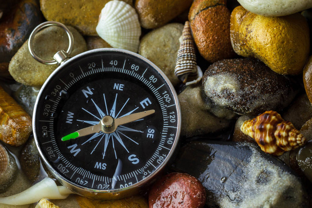 Compass on the pebbles and shell at riverside. Concepts of touri - Foto, Bild