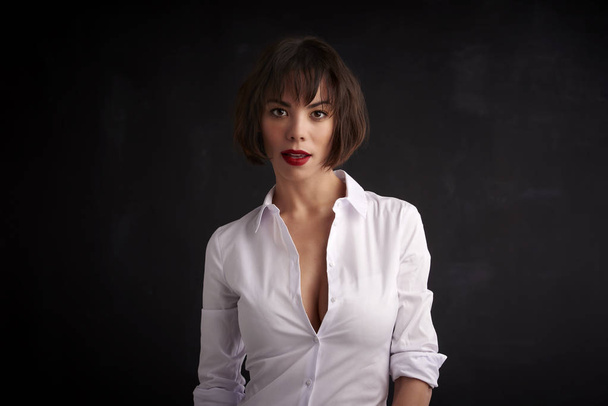 Attractive young woman wearing red lipstick and white shirt whil - Foto, imagen