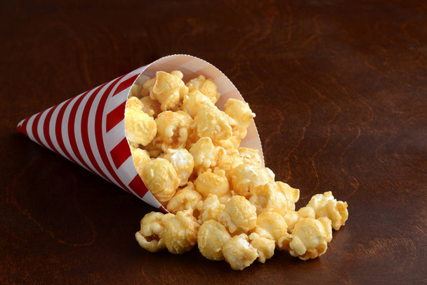 caramel popcorn in a red and white paper cone - Photo, Image
