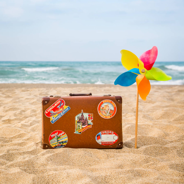 Vintage leather suitcase on the beach. Summer vacation and travel concept - Foto, imagen