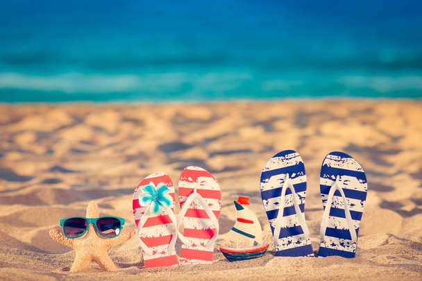 Os chinelos de praia na areia. Conceito férias de verão
 - Foto, Imagem