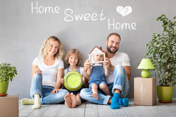 Happy family with two kids playing into new home. Father, mother and children having fun together. Moving house day and real estate concept - Foto, Imagen