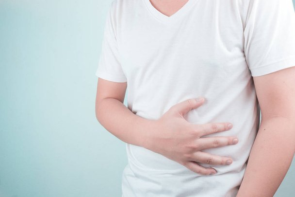 Asian Young men are suffering from stomach ulcers. gastritis Caused by the infection of H. pylori bacteria  healthcare and health problem concept - Photo, Image