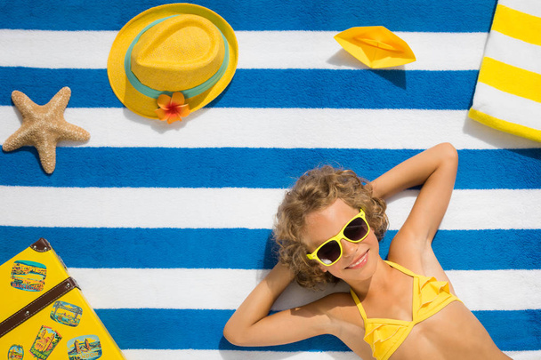 トップ ビュー ストライプ タオルの上に子供の肖像画。夏の休暇の概念 - 写真・画像