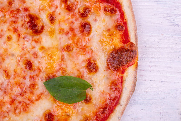 Een fragment van de pizza Margarita met een blad van de Groenen - Foto, afbeelding