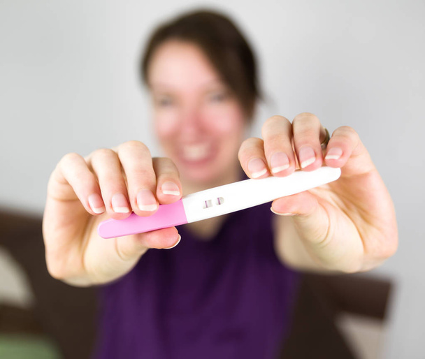 Femme heureuse avec test de grossesse
 - Photo, image
