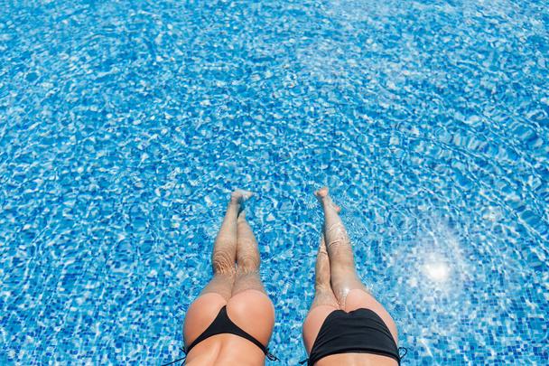 cropped view of two beautiful women at pool in water - Fotó, kép
