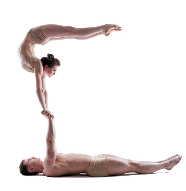 Image of two young acrobats balancing in studio - Fotó, kép