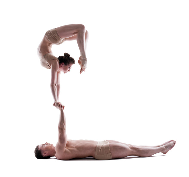 Young athletic gymnasts show acrobatic exercise - Valokuva, kuva