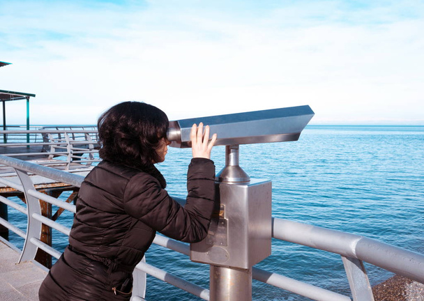 Γυναίκα ψάχνει στα κιάλια στο κατάστρωμα στη θάλασσα - Φωτογραφία, εικόνα
