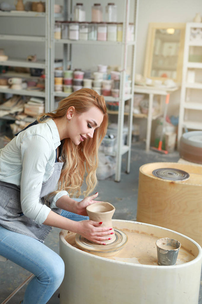 beautiful young girl makes a jug of clay in a pottery workshop - Foto, Bild