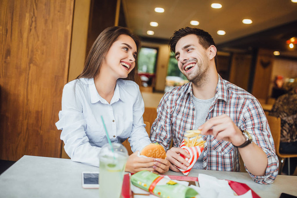 jonge mooie paar dating in café en glimlachend, concentreren op de voorgrond - Foto, afbeelding