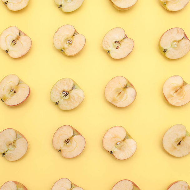 Background of cut in half apples on yellow background - Photo, image