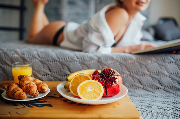 Focus at breakfast, woman lying on bed in background  - Foto, imagen
