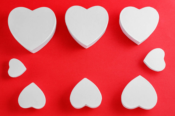 Corações de papelão feitos à mão em um fundo vermelho. O conceito é adequado para histórias de amor e para o Dia dos Namorados
 - Foto, Imagem