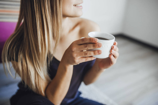 young beautiful woman drinking hot chocolate after successful online shopping at home - Фото, зображення