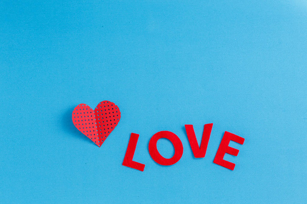 Δώρο κουτί σε σχήμα καρδιάς με μια κορδέλα πάνω σε μπλε φόντο. Η έννοια είναι κατάλληλη για την ημέρα του Αγίου Βαλεντίνου, τα γενέθλια και ερωτικές ιστορίες - Φωτογραφία, εικόνα