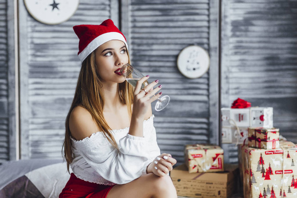 woman in christmas hat drinking champagne at bedroom - Foto, immagini