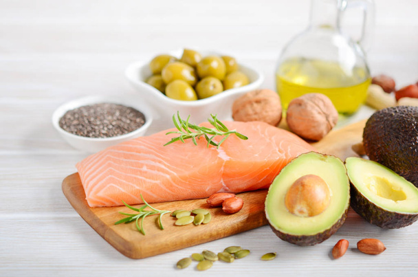 Selection of healthy unsaturated fats, omega 3 - fish, avocado, olives, nuts and seeds, selective focus. - Photo, Image