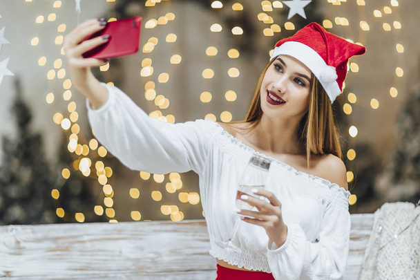 woman in christmas hat making selfie, celebrating new year  - Foto, Bild