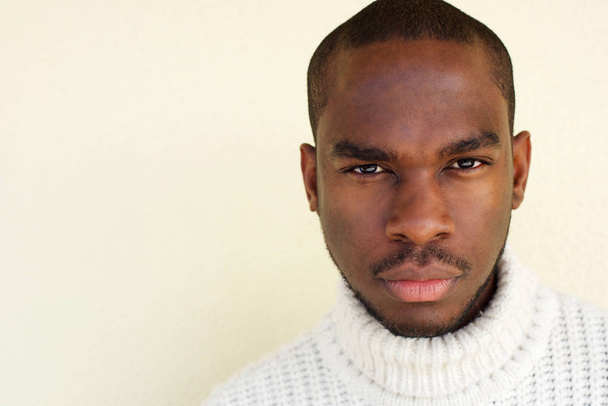 Close up portrait of handsome african man with sweater by wall - Valokuva, kuva