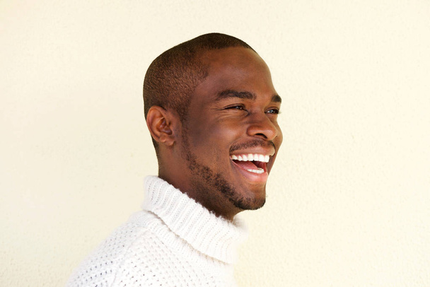 Detailní záběr straně portrét pohledný afroamerické muže v svetru smál a koukal - Fotografie, Obrázek