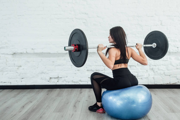 young woman doing weight lifting workout at gym  - Fotó, kép
