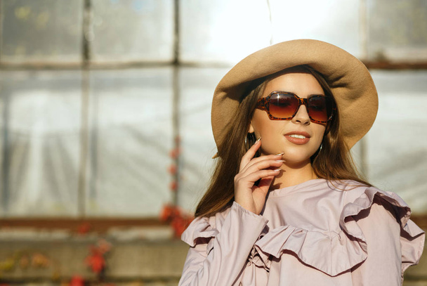 Trendy şapka ve güneş gözlüğü, o poz giymiş şık tabaklanmış model - Fotoğraf, Görsel