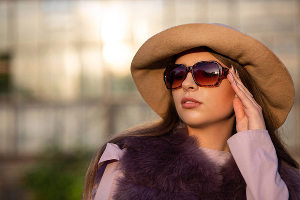Mulher bronzeada na moda usando chapéu da moda e óculos de sol, posi
 - Foto, Imagem