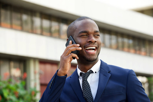 Крупним планом портрет чорного корпоративного бізнесмена, що розмовляє з мобільним телефоном у місті
  - Фото, зображення