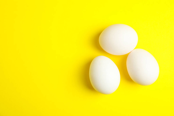 Huevos de pollo sobre fondo de color, espacio para texto
 - Foto, Imagen