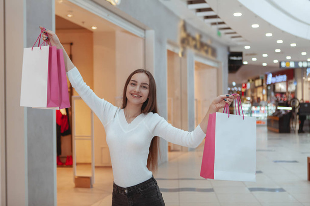 Linda jovem mulher fazendo compras no shopping local
 - Foto, Imagem
