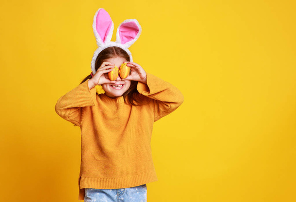 funny happy child girl with easter eggs  on yello - Φωτογραφία, εικόνα