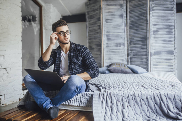 handsome blogger in glasses and laptop in hands, posing in studio  - Foto, imagen