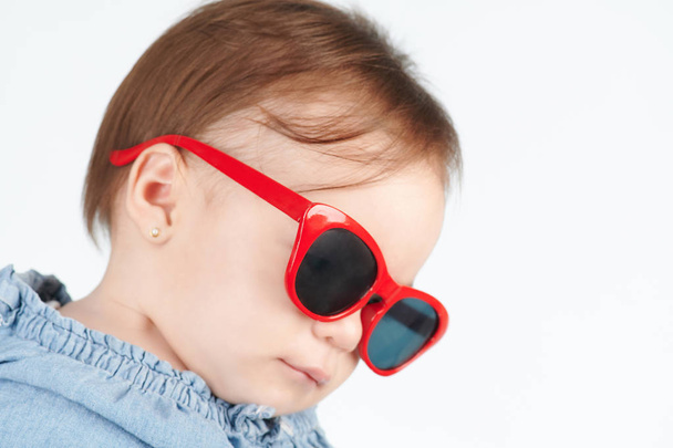 Глядя вниз ребенка в солнцезащитных очках
 - Фото, изображение