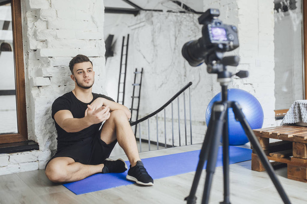 fitness blogger writing video for blog and telling basic rules during workout in loft style room - 写真・画像